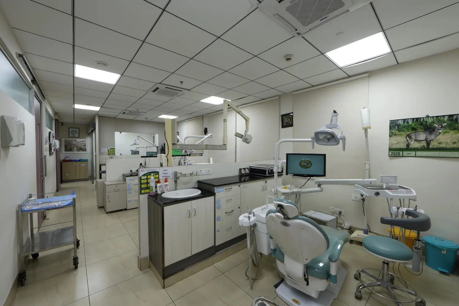 An empty dental room at SMF Hospital with a patient chair, dental equipment, and a sink.
